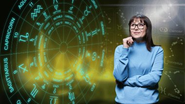 Há uma Roda do Zodíaco com os símbolos dos signos. Ao lado, há uma mulher que usa óculos olhando para cima.