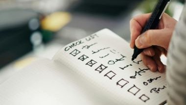 Imagem de uma pessoa fazendo anotações em um caderno, apontando tudo o que já foi cumprido/resolvido durante o ano.