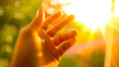 Imagem da fresta da luz do Sol e em destaque uma mão querendo pegar essa luz, simbolizando a espiritualidade.