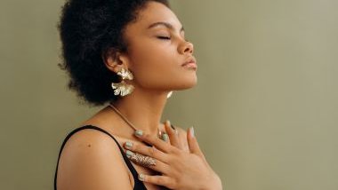 Imagem de uma moça negra fazendo a sua oração e meditação, simbolizando a conexão com a espiritualidade e a autoestima.