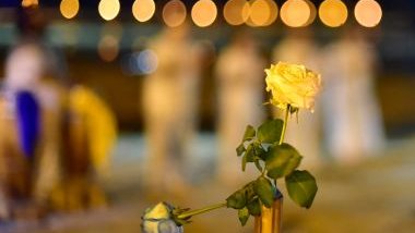 Imagem de um terreiro de umbanda meio desfocada e em destaque um rosa amarela aberta, simbolizando uma oferenda para Iemanjá.