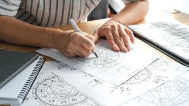 Imagem de uma astróloga traçando os desenhos de uma mandala astrológica para realizar as previsões dos signos.