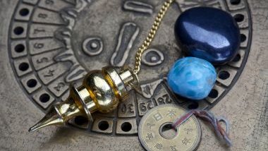 Imagem de uma mandala astrológica com cristais na cor azul sobre ela.