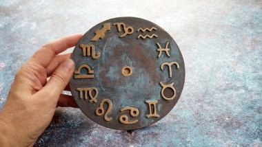 Imagem de uma mão segurando uma mandala astrológica feita de ferro.