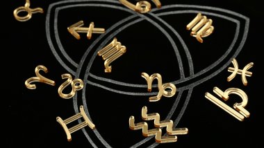 Os símbolos dos signos do zodíaco estão espalhados sobre uma superfície na cor preta.