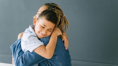 Imagem de uma mãe abraçando o seu filho.