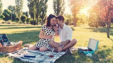 Imagem de um casal fazendo pic-nic em um parque, celebrando o dia dos namorados.
