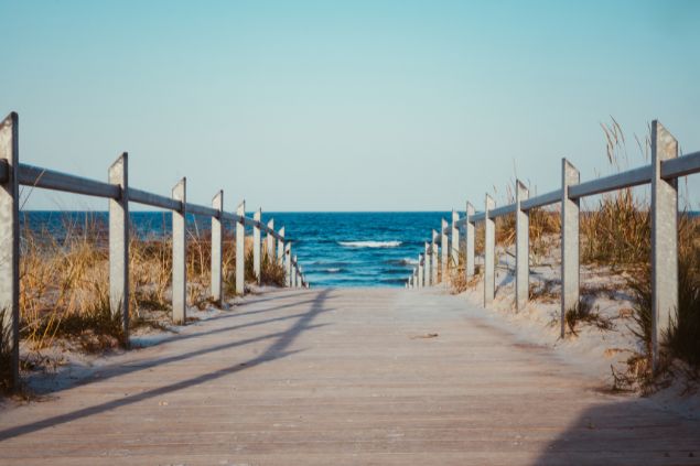 Caminho rumo a praia com um mar de fundo