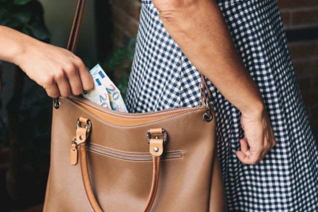 ladrão roubando dinheiro de uma bolsa