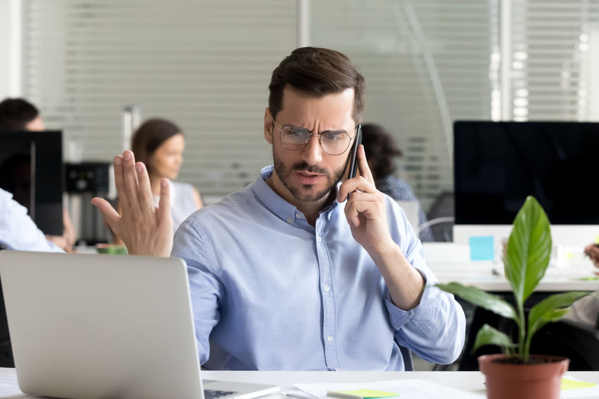 Homem reclamando enquanto fala no celular