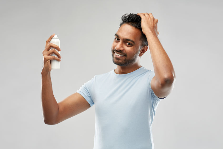 Homem passando spray no cabelo 