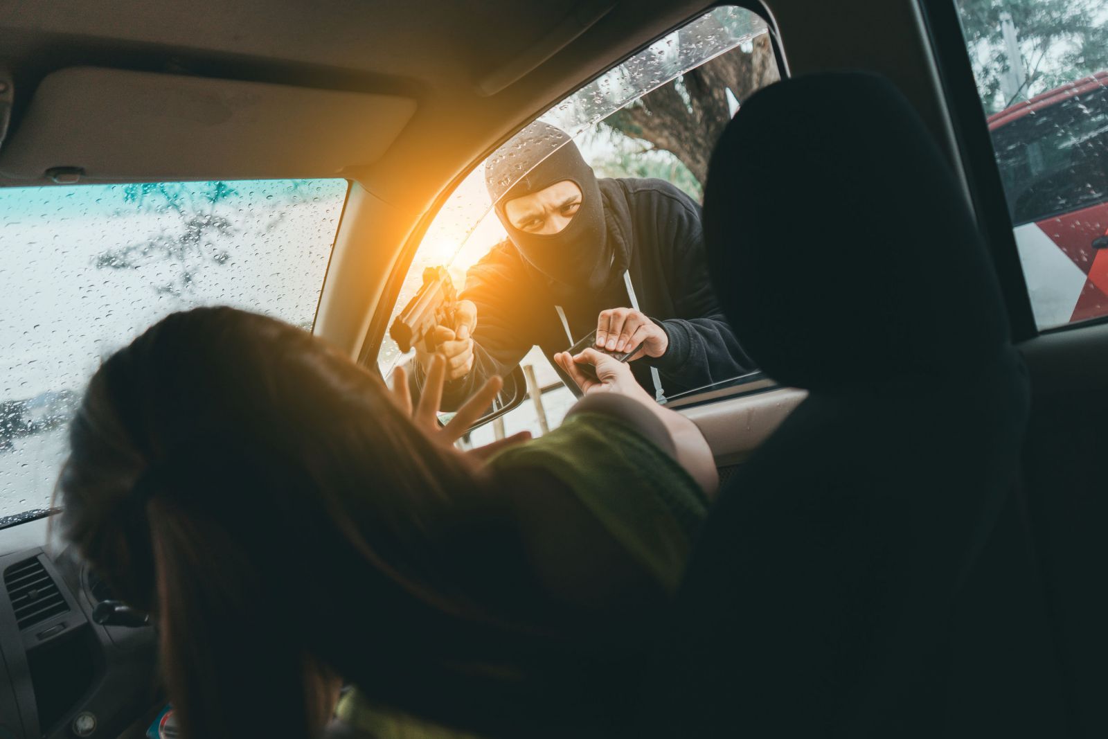 Ladrão roupando carro com uma arma