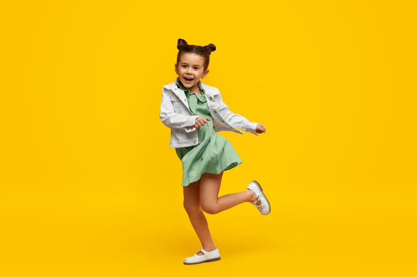 Criança sorrindo em fundo amarelo 