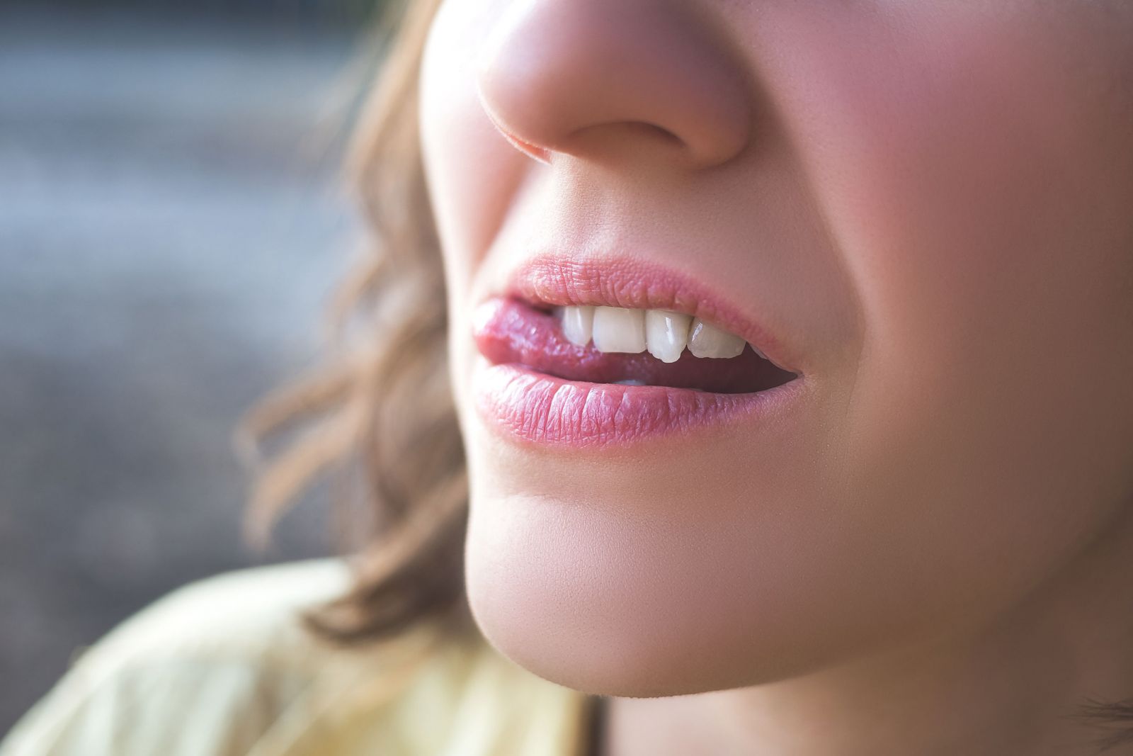 Mulher passando sua língua no dente