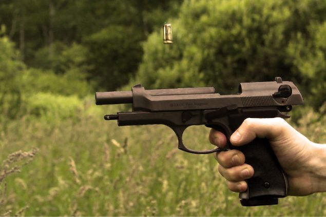 pessoa disparando arma de fogo