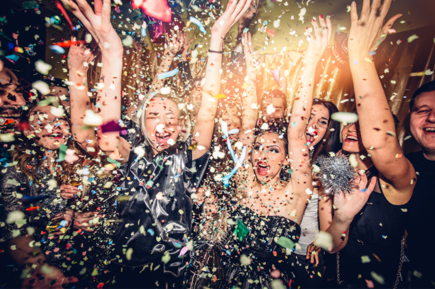Pessoas cobertas de confete em uma festa