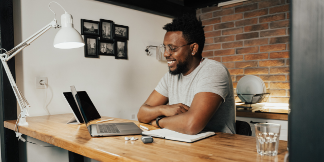 Homem sorrindo enquanto trabalha no escritório