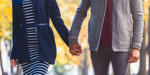 Casal caminhando de mãos dadas no parque