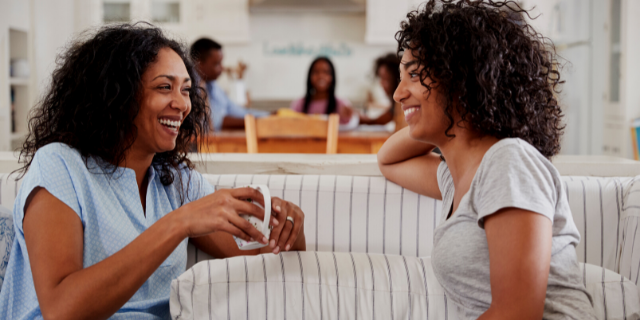 Casal sorrindo e conversando na sala