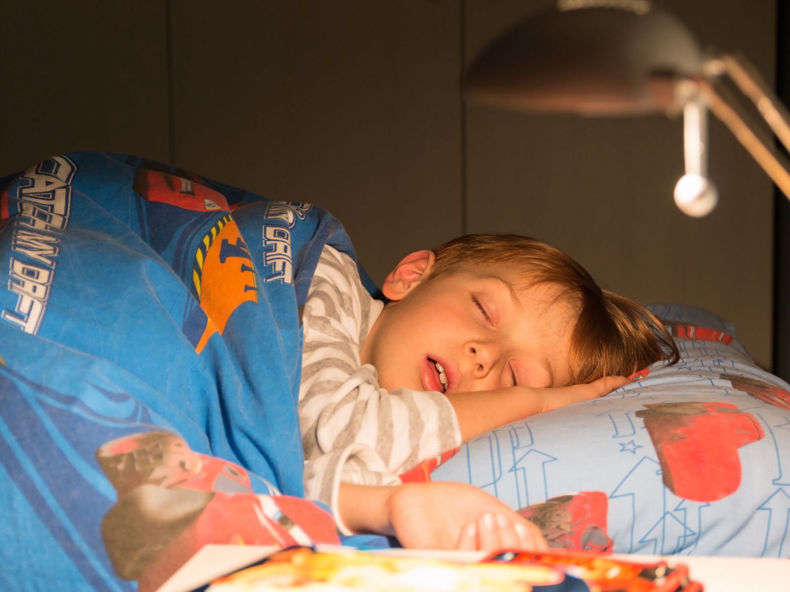 Criança dormindo na cama do quarto