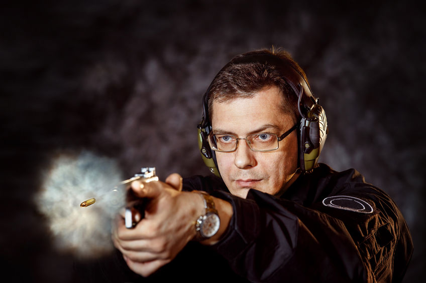 Homem disparando com uma pistola
