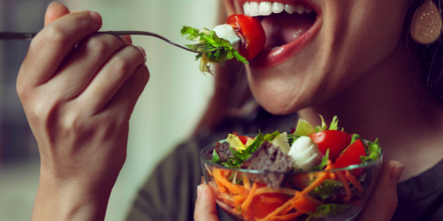Mulher comendo salada