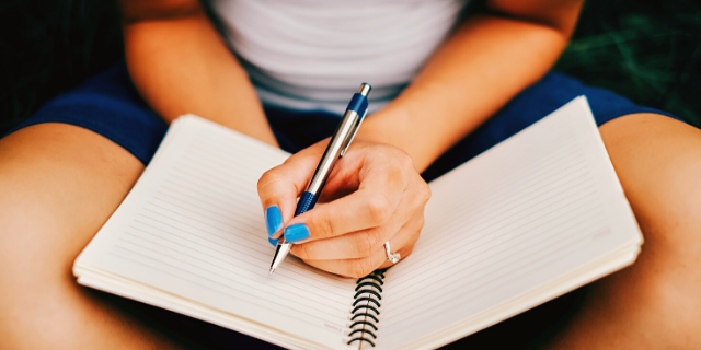 Mulher anotando em seu caderno