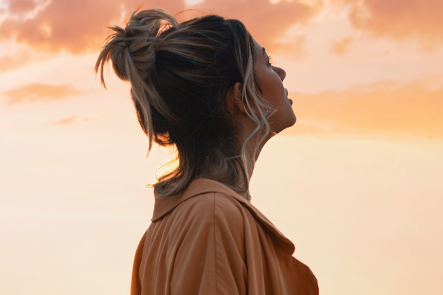 Mulher observando o céu durante o por do sol