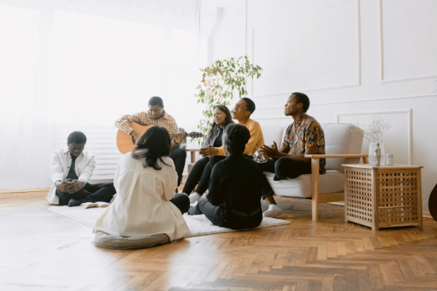 Jovens reunidos sentados e cantando louvores. 