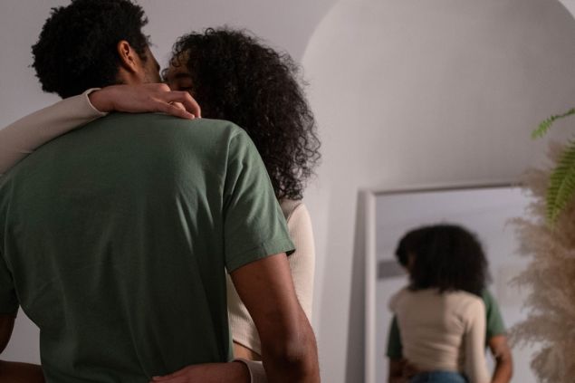 casal hetero se beijando e reflexo dos dois no espelho atrás
