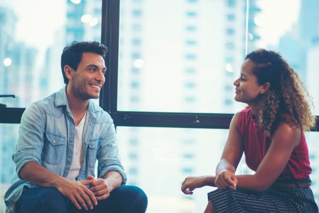 Imgem de um homem e uma mulher conversando e sorrindo