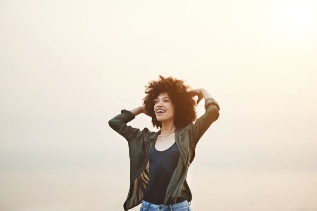 Imagem de uma mulher sorrindo ao ar livre