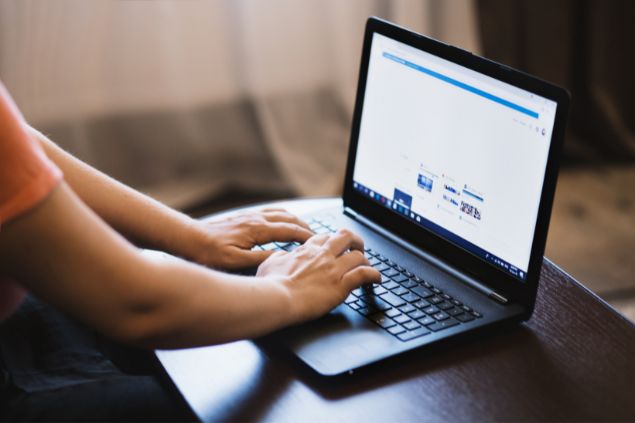 Imagem de uma pessoa pesquisando sobre algo em seu laptop