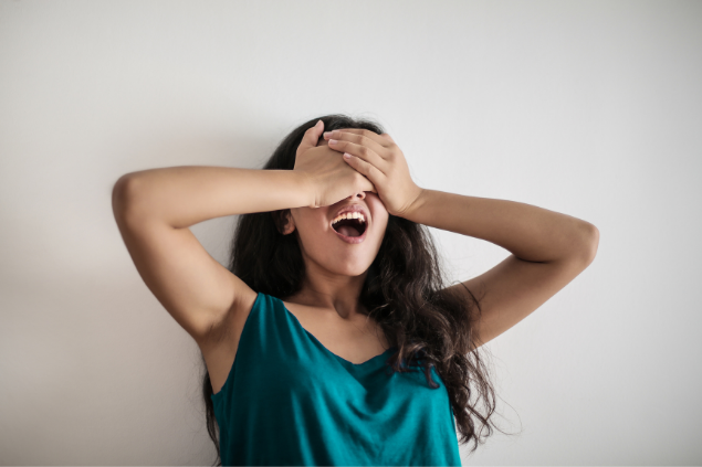 Menina com as mãos tapando os olhos