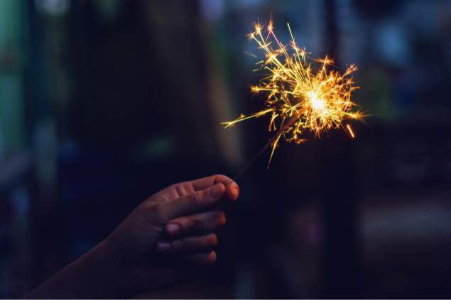 Mão segurando uma vela estrelinha