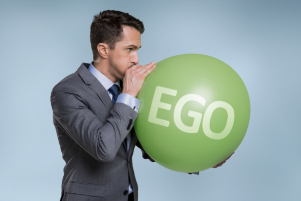 Homem enchendo um balão escrito EGO