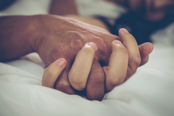Mãos de casal entrelaçadas 