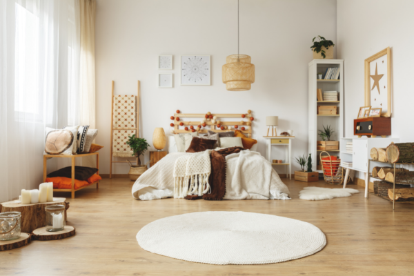 Quarto com um tapete branco no chão, em frente à cama