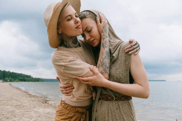Duas mulheres abraçadas na beira do mar