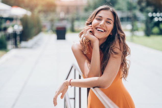 Imagem de uma mulher sorrindo e parece muito feliz