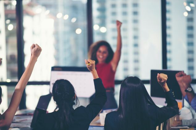 Imagem de uma equipe de trabalho comemorando o sucesso