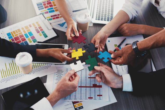 Grupo de trabalho reunido com peças de quebra-cabeça. Conceito de trabalho em equipe. 