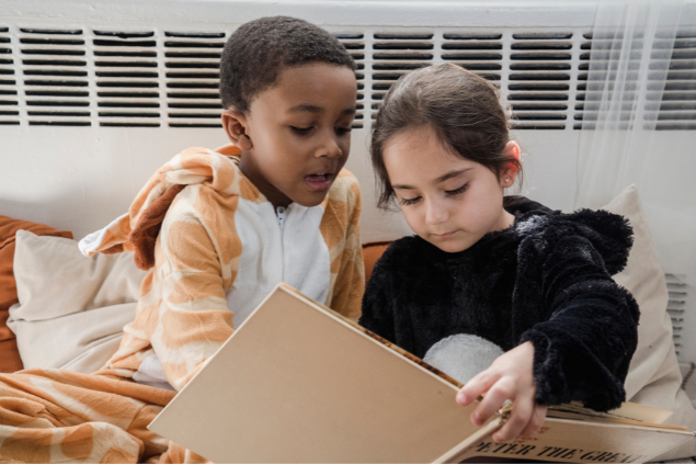 Um menino e uma menina lendo um livro