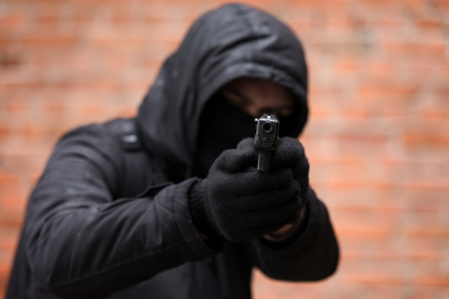 Homem apontando arma para câmera