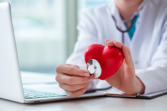 Médica ouvindo um coração de borracha