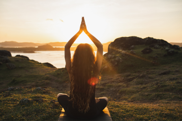 Pessoa meditando ao por do sol