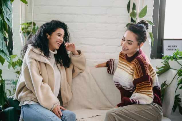 Duas mulheres sentadas no sofá conversando