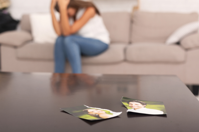 Mulher chorando com uma foto rasgada de ex namorado