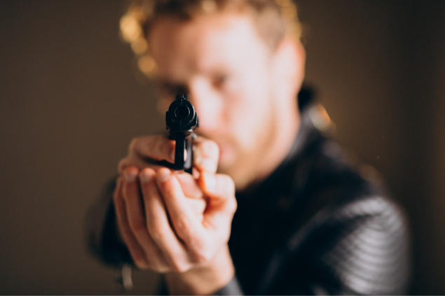 Homem apontando a arma para a câmera