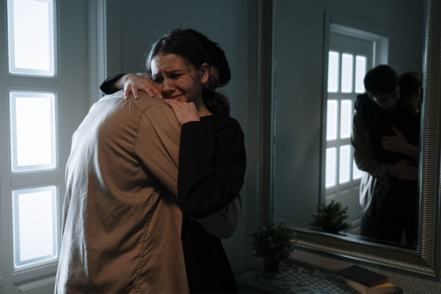 Mulher chorando abraçando um homem